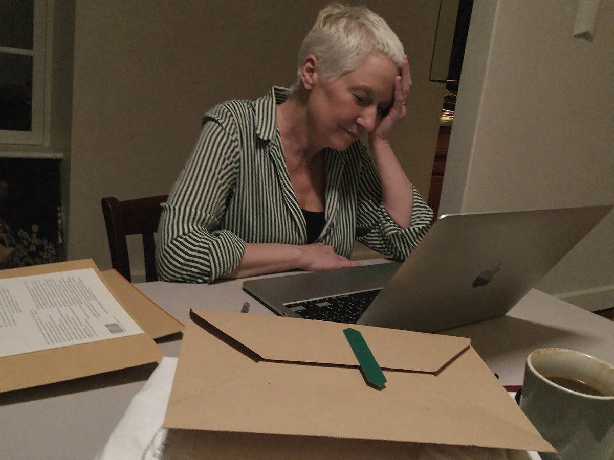 Woman at a laptop with family documents